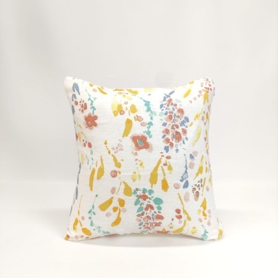 Almofada quadrada com padrão floral colorido sobre fundo branco