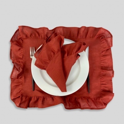 Guardanapo e base de prato vermelhos com folho, prato branco, garfo e faca