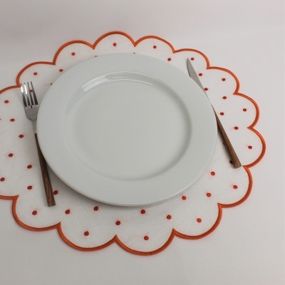 Prato branco com talheres e sousplat branco com detalhes vermelhos