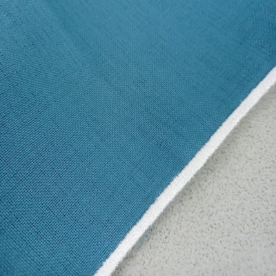 Pano de tecido azul com borda branca sobre superfície clara