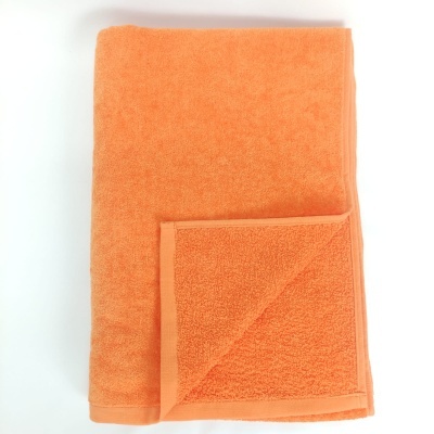 Toalha de algodão laranja dobrada mostrando textura felpuda