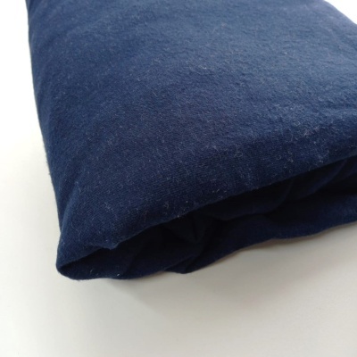 Tecido azul escuro dobrado sobre superfície branca