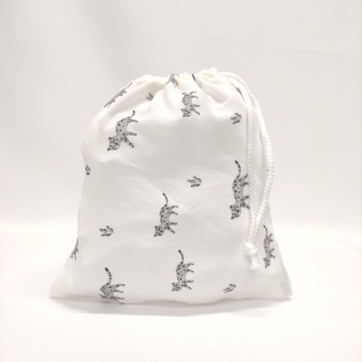 saco de tecido branco com padrão de leopardos e cordão de fecho