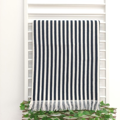 Toalha ou manta riscada azul e branca com franjas pendurada