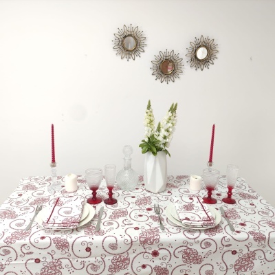 Mesa de jantar decorada com toalha branca e vermelha, pratos, copos, taças, castiçais, flores e espelhos na parede