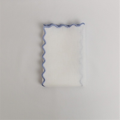 Guardanapo branco com borda azul ondulada