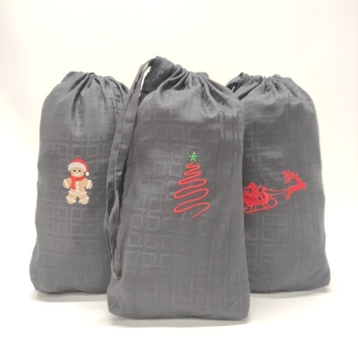 Três sacos de tecido cinzento com desenhos bordados natalícios