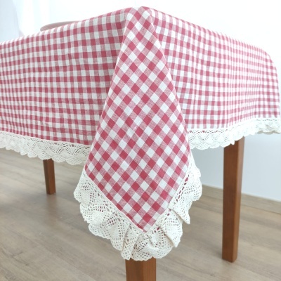 Toalha de mesa xadrez vermelha e branca com borda de renda numa mesa de madeira