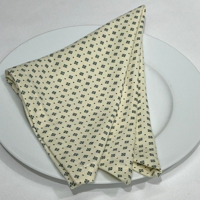 Guardanapo creme com padrão preto sobre prato branco