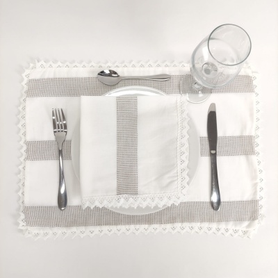 Jogo americano branco e cinza com guardanapo, talheres de aço e copo de vidro transparente