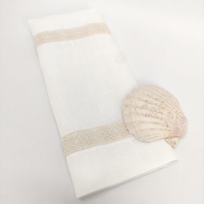 Toalha branca com faixas bege e concha natural