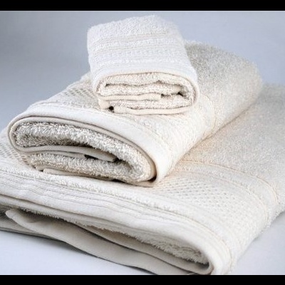 Conjunto de toalhas creme empilhadas sobre superfície branca