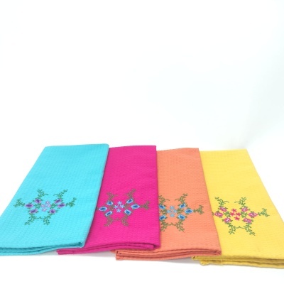 Quatro toalhas coloridas com bordados florais alinhadas