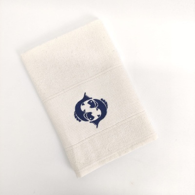 Toalha branca com bordado azul de dois peixes em círculo