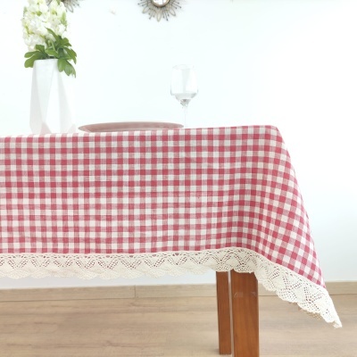Toalha de mesa xadrez vermelho e branco com borda rendada numa mesa de madeira