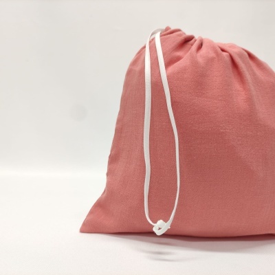 Saco de tecido rosa com cordão branco sobre fundo branco