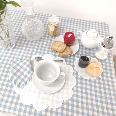 Conjunto de chá em porcelana branca com toalha xadrez azul e branca