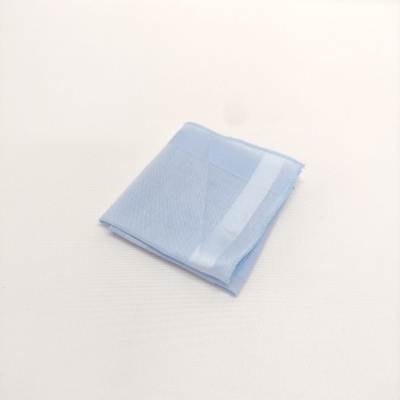 Pano azul claro dobrado com listra branca numa superfície branca