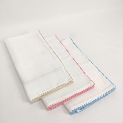 Três panos de linho brancos com bainhas bordadas em zig-zag colorido