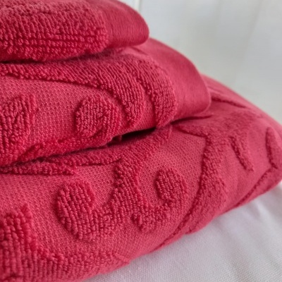 Toalhas cor de rosa com padrão texturizado sobre superfície branca