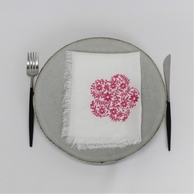 Conjunto de talheres, prato cinzento e guardanapo branco com padrão floral rosa