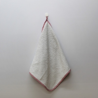 Toalha pequena cinzenta com borda rosa pendurada