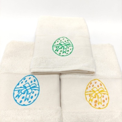 Três toalhas brancas com bordados de ovos coloridos