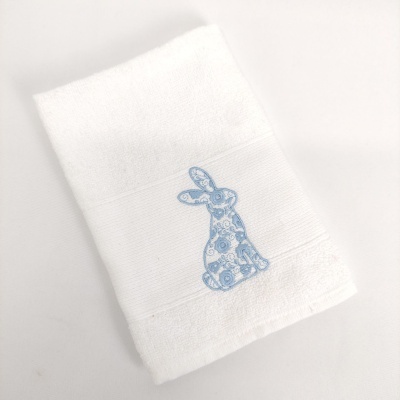 Toalha branca com bordado azul de coelho