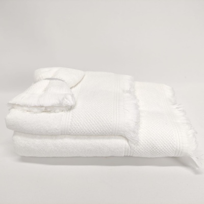 Toalha branca com franjas e padrão texturizado