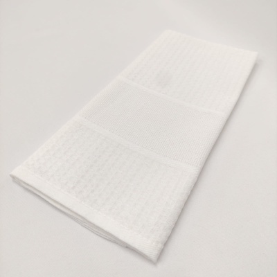 Toalha branca dobrada com texturas e faixas distintas