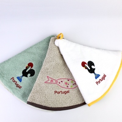 Três toalhas triangulares bordadas com motivos portugueses e a palavra Portugal.