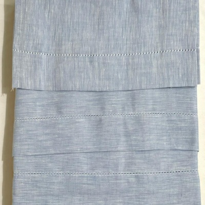 Toalha azul claro dobrada com linhas de costura decorativa