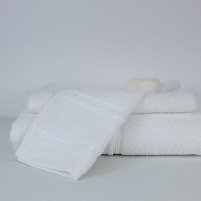 Três toalhas brancas empilhadas com sabão em barra em fundo branco