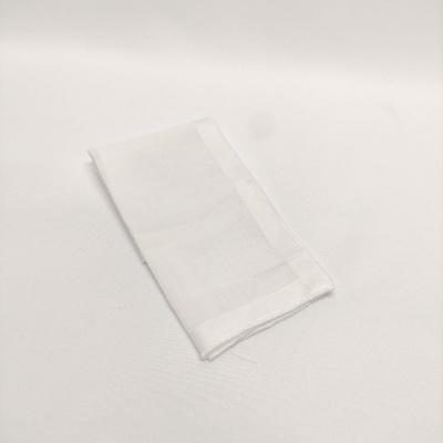Toalhete de tecido branco dobrado sobre superfície branca