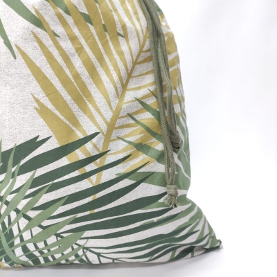 Almofada de tecido com estampa de folhas verdes e bege e cordão verde claro