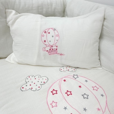 Almofada e capa branca bordadas com balões e nuvens cor-de-rosa