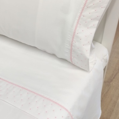Conjunto de roupa de cama branca com bordado rosa e padrão pontilhado