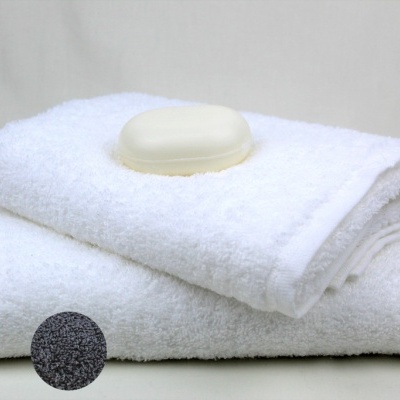 Toalhas brancas empilhadas com sabão em barra em cima