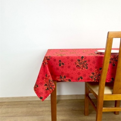 Manteleira vermelha com padrão floral preta e dourada numa mesa de madeira