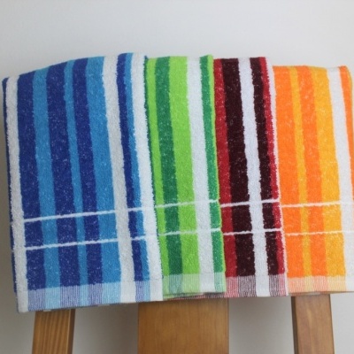 Toalhas de banho coloridas com riscas sobre cadeira de madeira