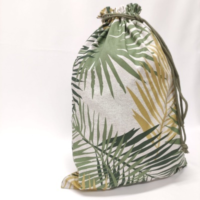 Saco de tecido com padrão de folhas verdes e amarelas num fundo branco