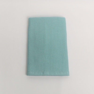 Pano de cozinha azul claro com textura quadriculada dobrado