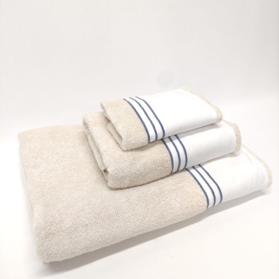 Três toalhas bege com faixas brancas e linhas azuis empilhadas.