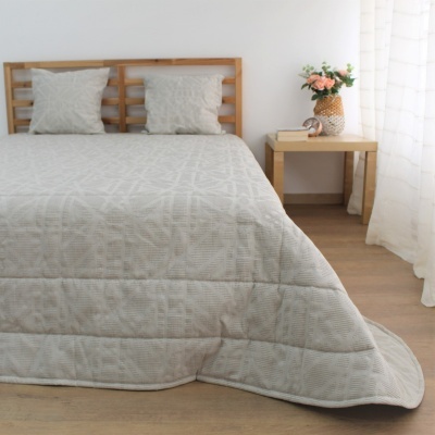 Cama com colcha cinza e almofadas, mesa de cabeceira com vaso de flores, quarto minimalista