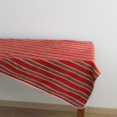 Toalha riscada vermelha, branca e castanho sobre mesa de madeira