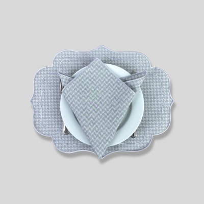 Jogo americano e guardanapo cinza com padrão pied-de-poule e prato branco