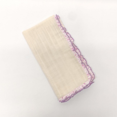 Toalha creme com borda floral rosa e renda lilás sobre fundo branco