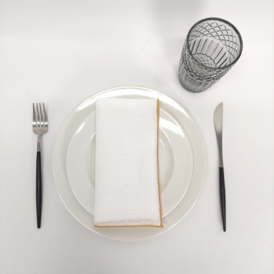 Conjunto de refeição com prato branco, guardanapo, garfo, faca e copo transparente