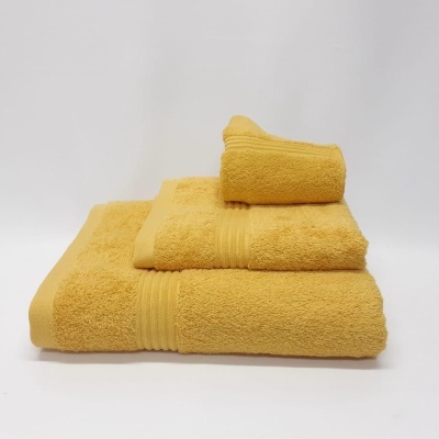 Conjunto de toalhas amarelas empilhadas sobre fundo branco