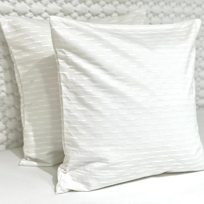 Duas almofadas brancas texturizadas sobre superfície branca